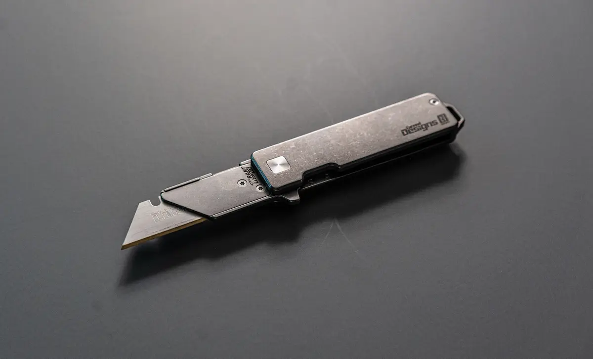 TiRant RAZOR V3 titanium utility knife, stonewashed, on a dark ground